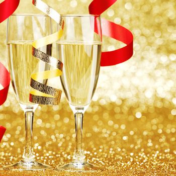 New year champagne and ribbons on golden background