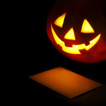 Halloween pumpkin lantern and blank post card on black background