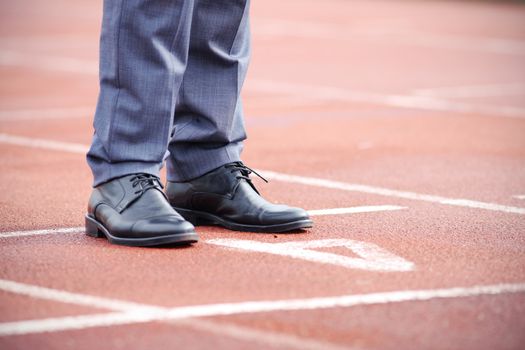 Businessman standing on the start line close up of shoes