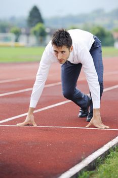 A businessman on a track ready to run 