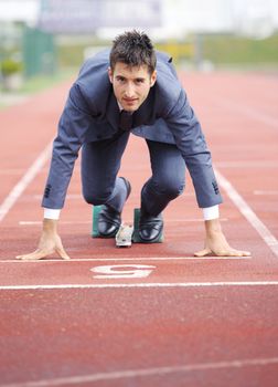 A businessman on a track ready to run 