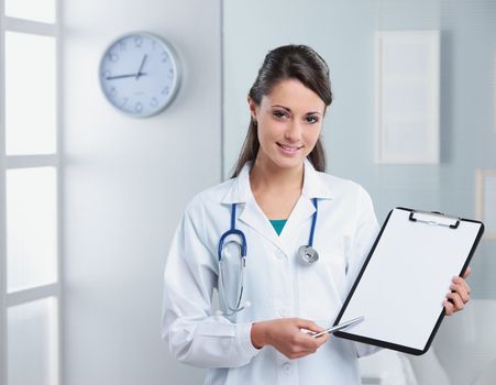 Confident woman doctor pointing at the clipboard