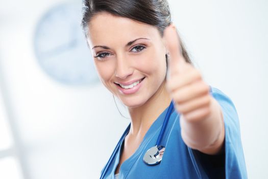 Young female doctor gesturing with thumbs up