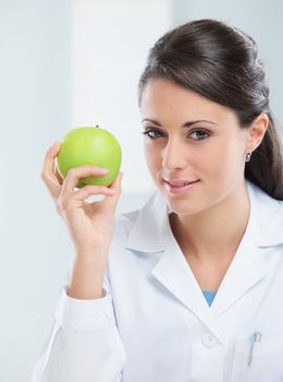 Nutritionist female Doctor holding a green apple