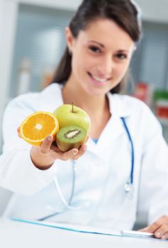 Nutritionist Doctor holding some fruits in her hand