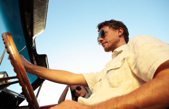 Couple taking a road trip in vintage convertible