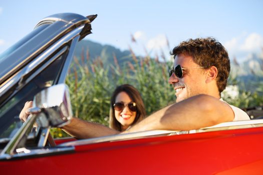 Beautiful couple enjoying in a convertible car ride