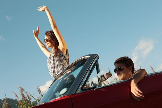 Happy young people in a convertible car
