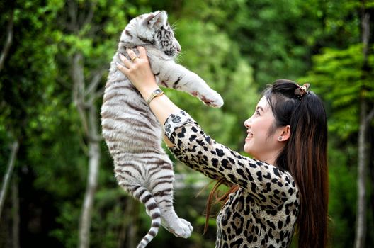 pretty women hold baby white bengal tiger