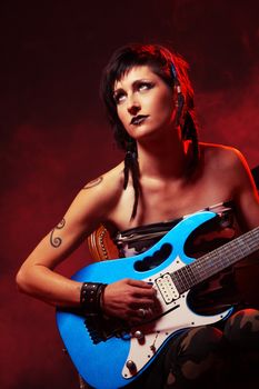 Female guitarist playing guitar at a rock concert