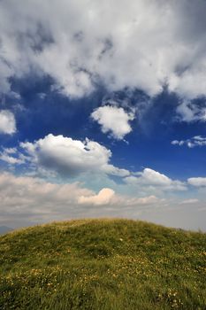 a grassy hill silhouetted against the blue sky