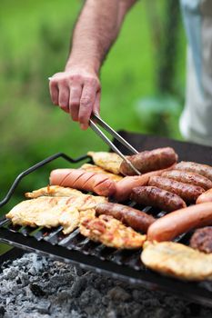 Grilling at summer weekend. Fresh meat preparing on grill.