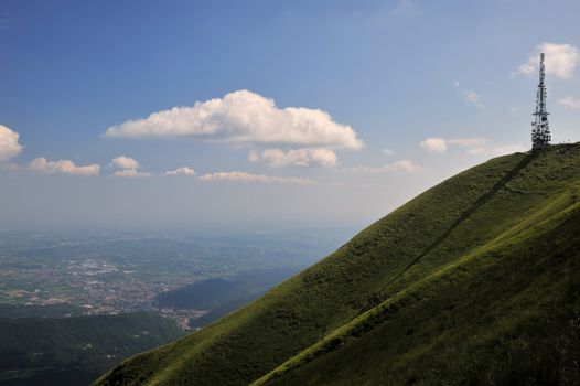 a television antenna watches over the valley from the top of a green hill, like a silent sentinel