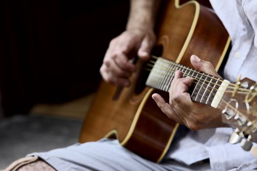 Closeup of acoustic guitar and the musician hands, shallow deep of field