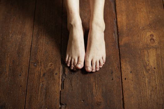 Cropped image of female bare feet on a wooden floor