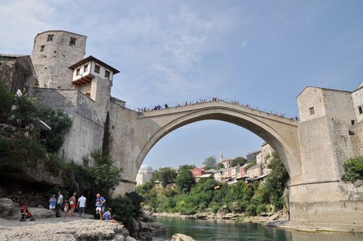 MOSTAR, BOSNIA-HERCEGOVINA AUGUST 10: Tourist at the old bridge of Mostar which was destroyed in the war and rebuild in 2004. Taken on August 10, 2013 in Mostar, Bosnia. 