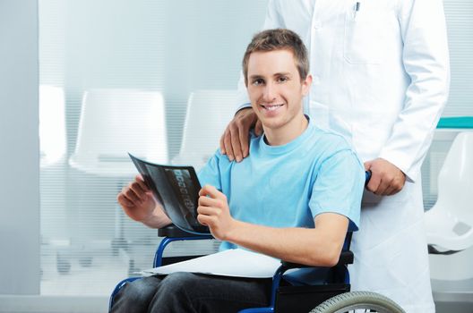 Male nurse pushing her disabled patient on a wheelchair. 