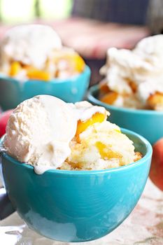 Fresh peach cobbler served with vanilla ice cream.