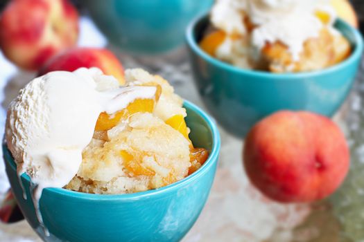 Fresh peach cobbler served with vanilla ice cream.