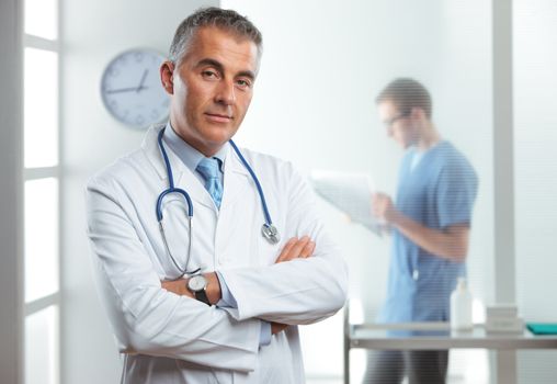 Portrait of a handsome male doctor, nurse on background