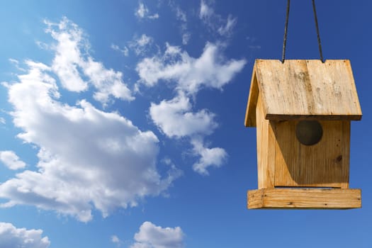 Old wooden birdhouse on a blue sky with free space for text