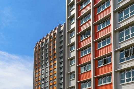 A close up shot of a new colorful high rise apartment against the sky.