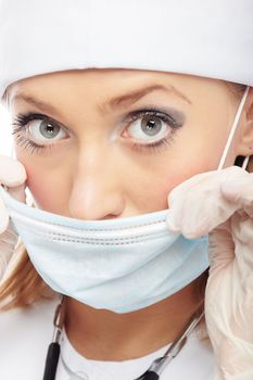Female doctor in latex gloves holding the protective mask