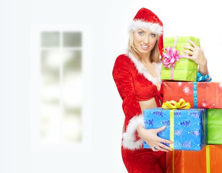 Smiling lady in Santa Claus costume holding the Christmas gifts