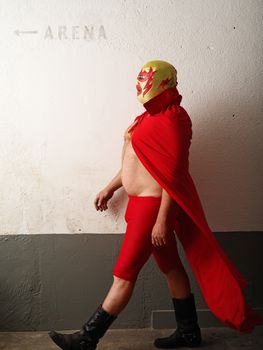 Photograph of a Mexican wrestler or Luchador walking to the wrestling arena. Slight motion blur visible.