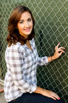 Young woman smiling in front construction fence.