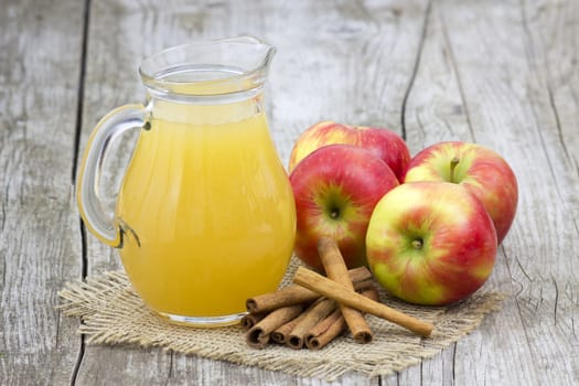 Apple juice and apples on wooden background