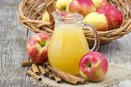 Apple juice and apples on wooden background