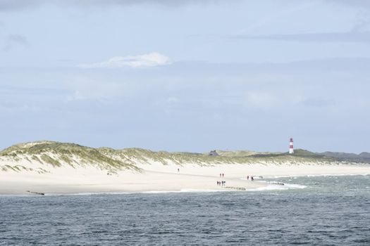 Beach on Sylt with lighthouse of List in the background, Germany