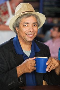 Smiling African man with hat and coffee cup