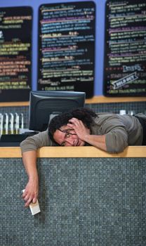 Stressed out worker laying on cafe counter