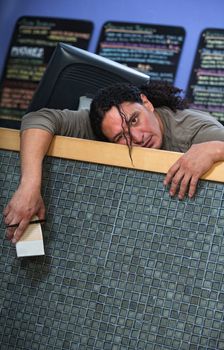 Bored male restaurant owner at counter with receipt book