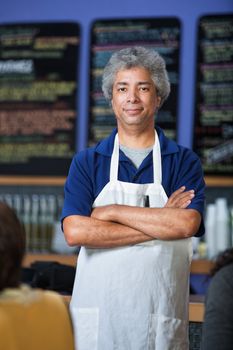 Confident mature Arab cafe waiter with apron