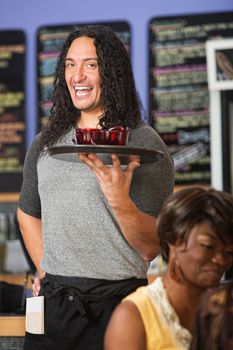 Happy Native American cafe owner serving drinks to customers