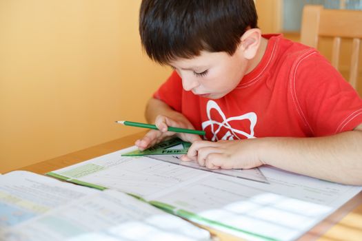 boy doing school homework from geometry mathematics in workbook
