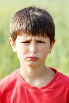 outdoor portrait of sad young teenager boy with shallow focus