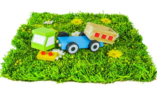 Crushed toy truck on a grass on white background