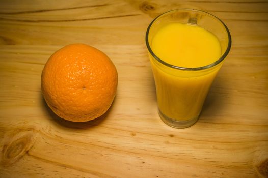 Orange and orange juice on a wooden table