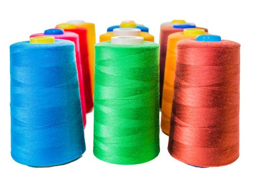 Colored fine thread bobbins on white