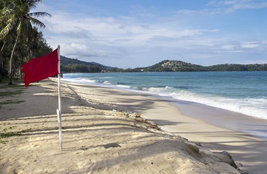 Red flag flying on Bang Tao beach, Phuket, Thailand indicating that it is dangerous to swim