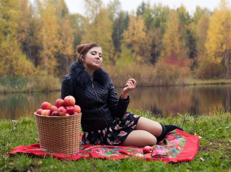 haughty woman with a basket of apples on a picnic