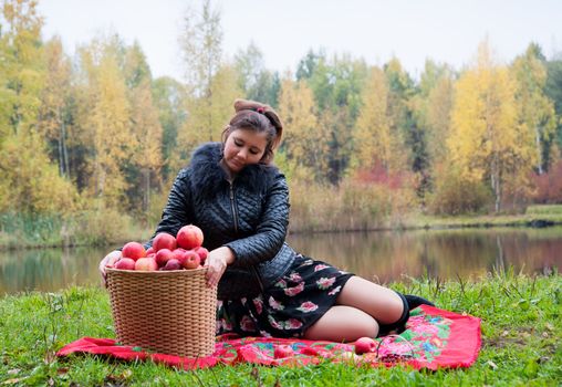 haughty woman with a basket of apples on a picnic