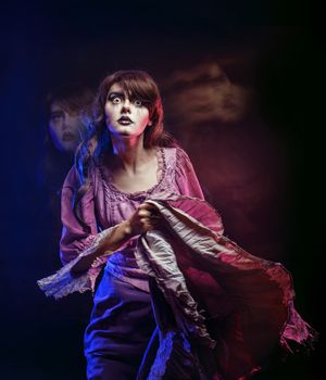 Girl in the image of a witch with a theatrical make-up in studio shot