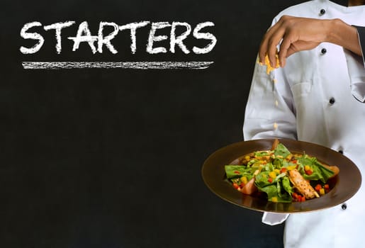 Chef with chalk starters sign written on blackboard background