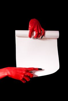 Red devil hands with black nails holding paper scroll and pointing at signature place  
