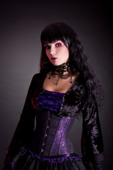 Portrait of beautiful gothic girl wearing Halloween costume, studio shot on black background 